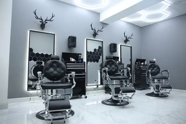 The shop: barber chairs, lit mirrors and stag heads on the wall
