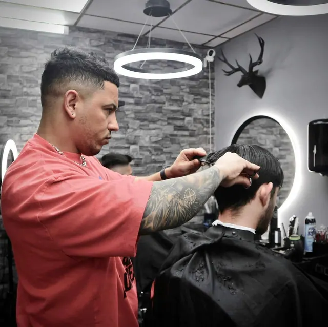 A barber at work under a ring light