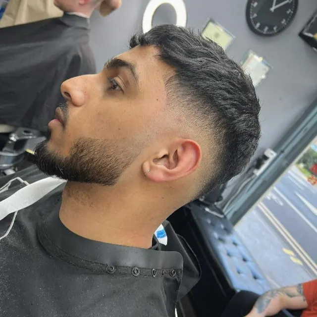 A textured cut with a fade and a shaped beard